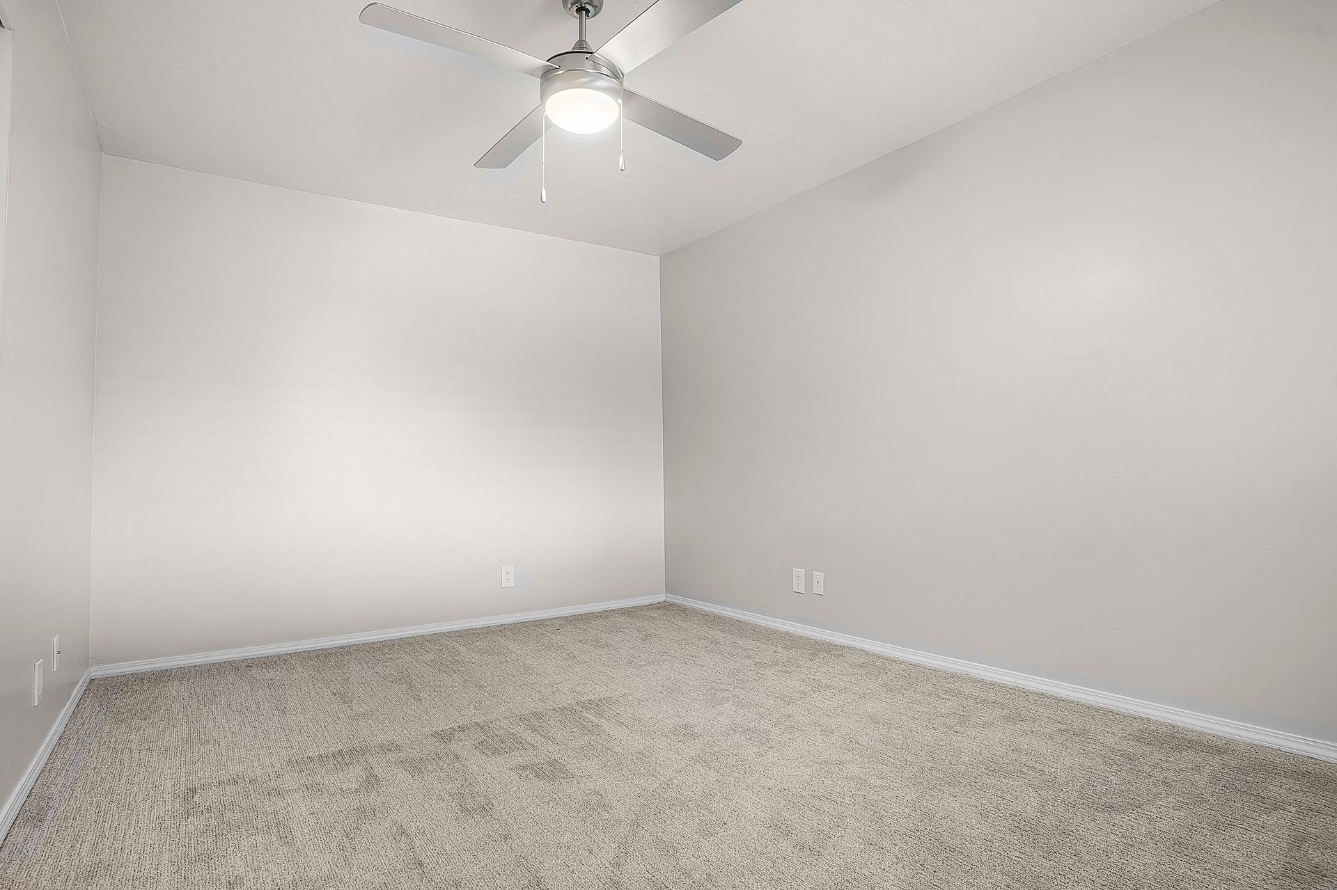 Modern kitchen with stainless steel appliances, light wood cabinets, white countertops.