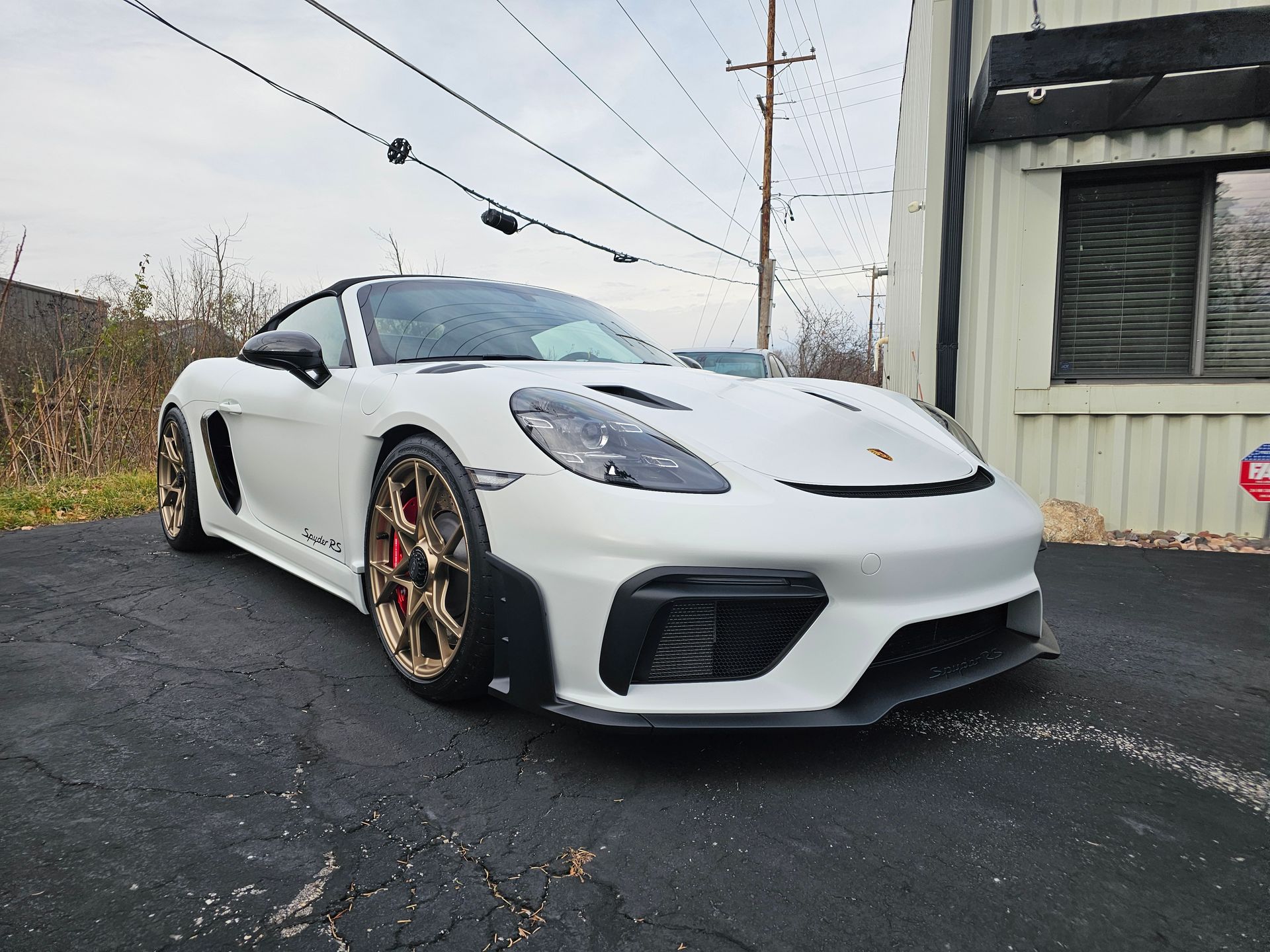 Person wearing black gloves applying ceramic coating to a black car's hood with an applicator.