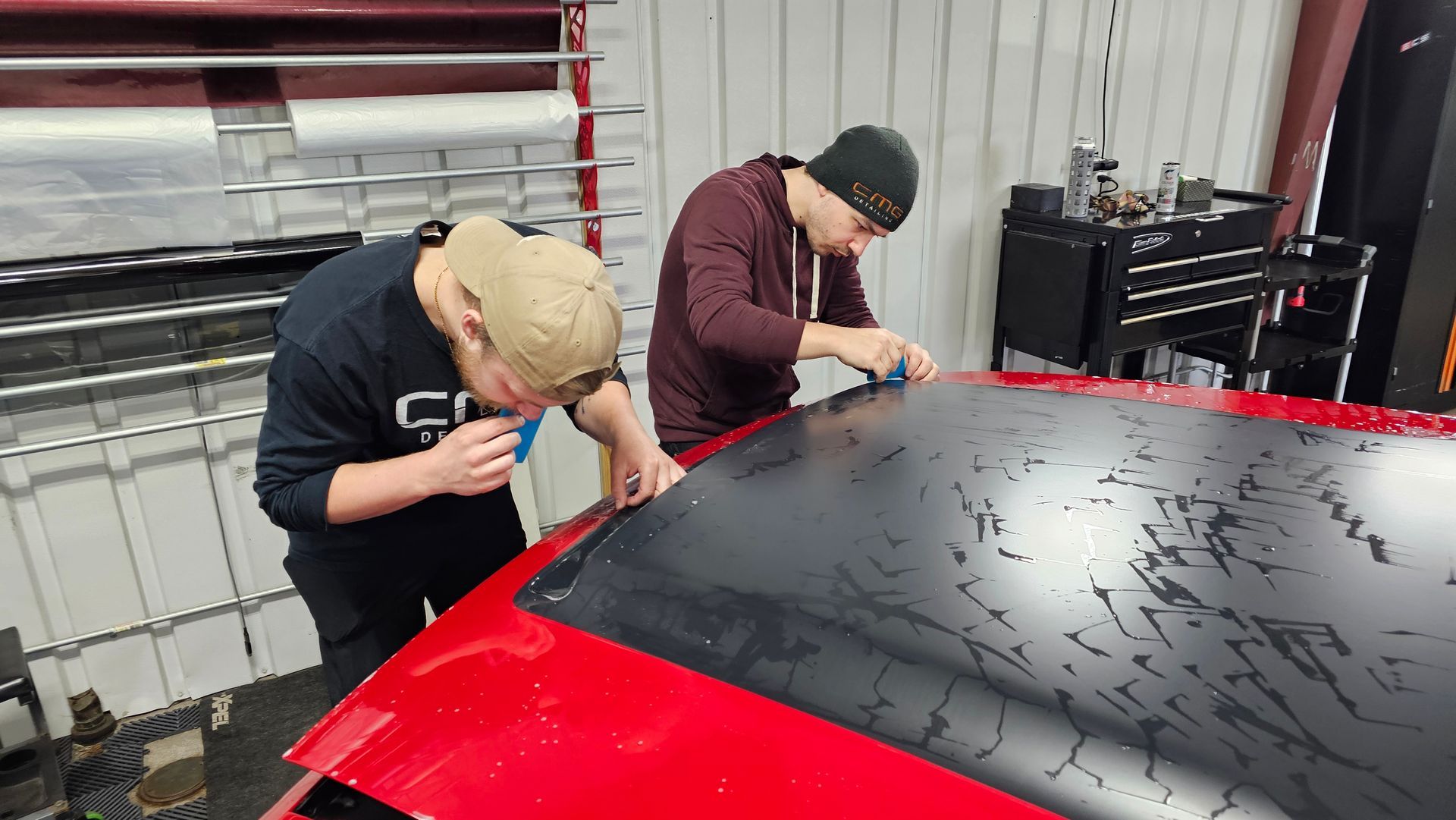 Woman spraying a large white surface on a folding table in a shop.