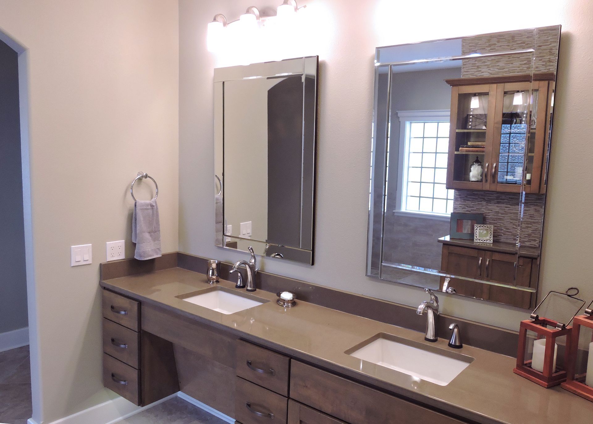 A hallway view with a central room behind double doors, a left passage, and a right staircase with light tan walls.