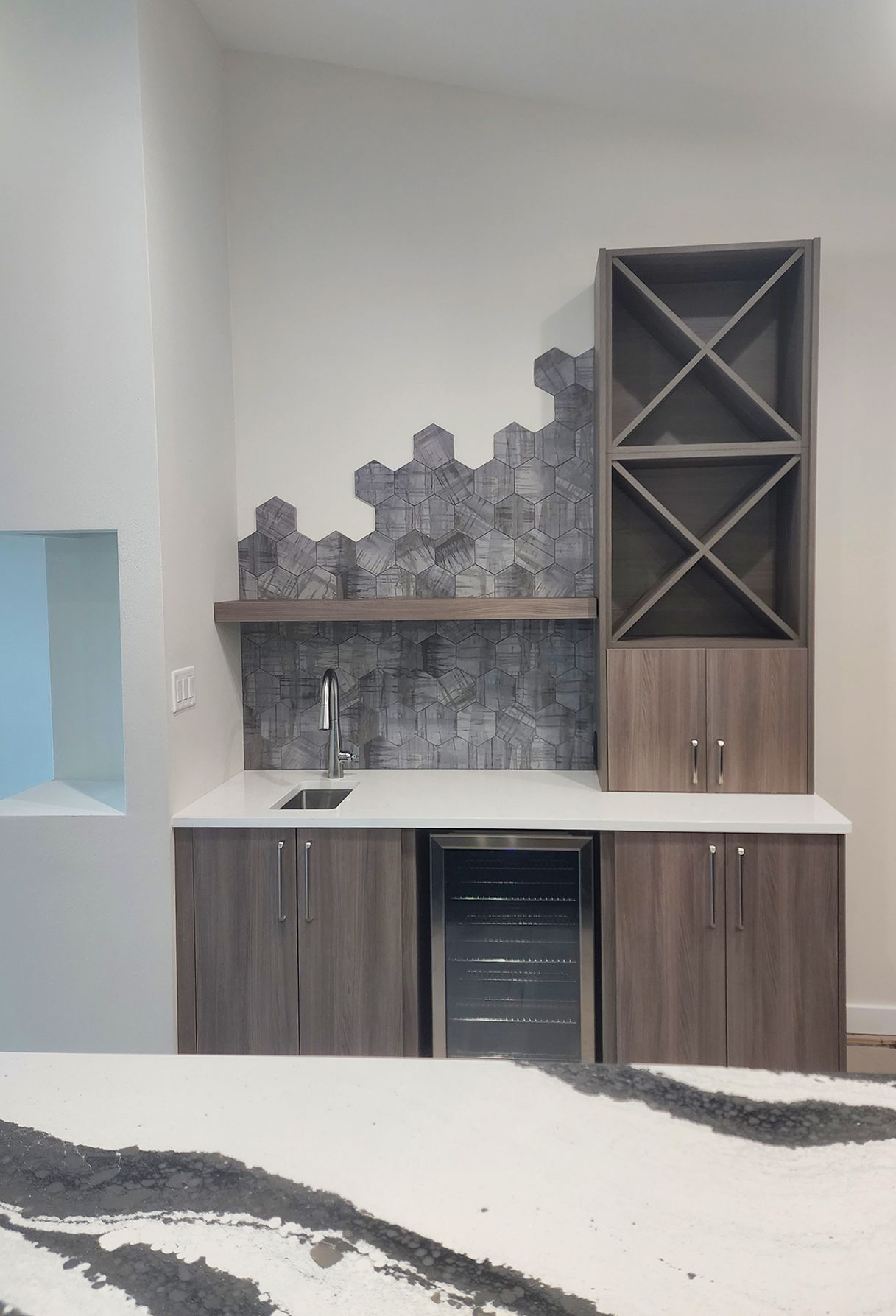 A bright bathroom with dark wood cabinets, granite countertops, a built-in vanity, a soaking tub, and a glass shower.
