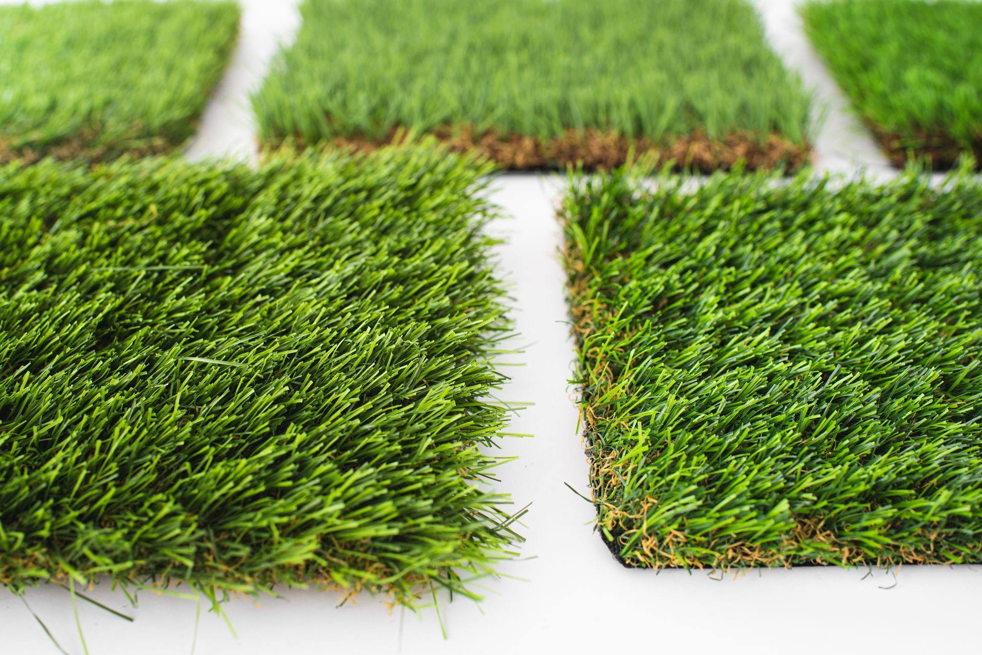 Close-up view of synthetic artificial grass material, showcasing its texture and vibrant green fibers.