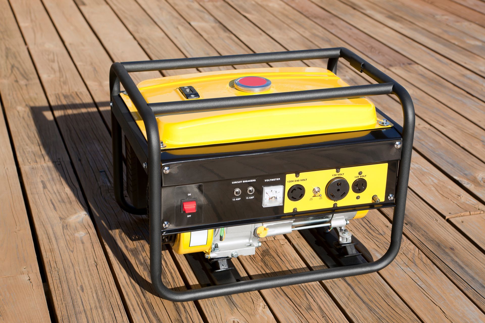 Yellow and black portable generator on wooden deck, contained by a black metal frame.