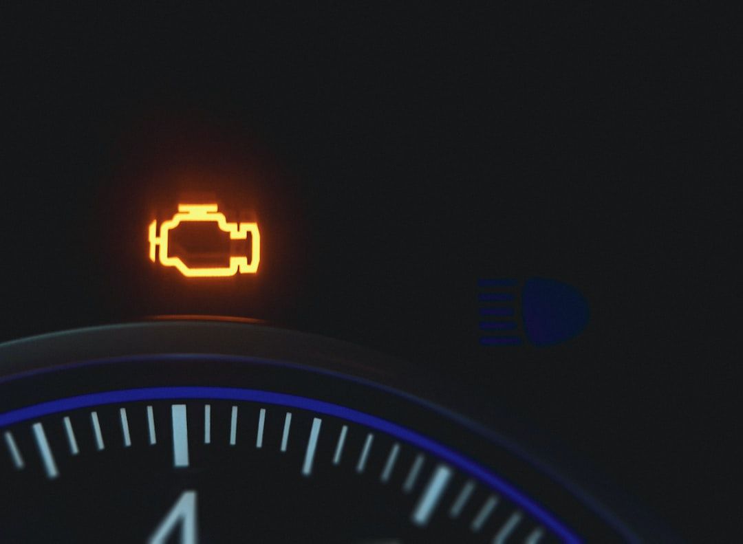 Illuminated orange engine warning light on a car dashboard.