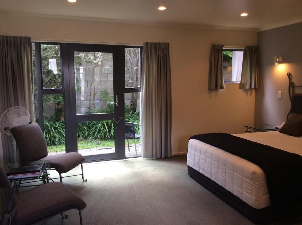 A bedroom with a bed , chair and sliding glass doors