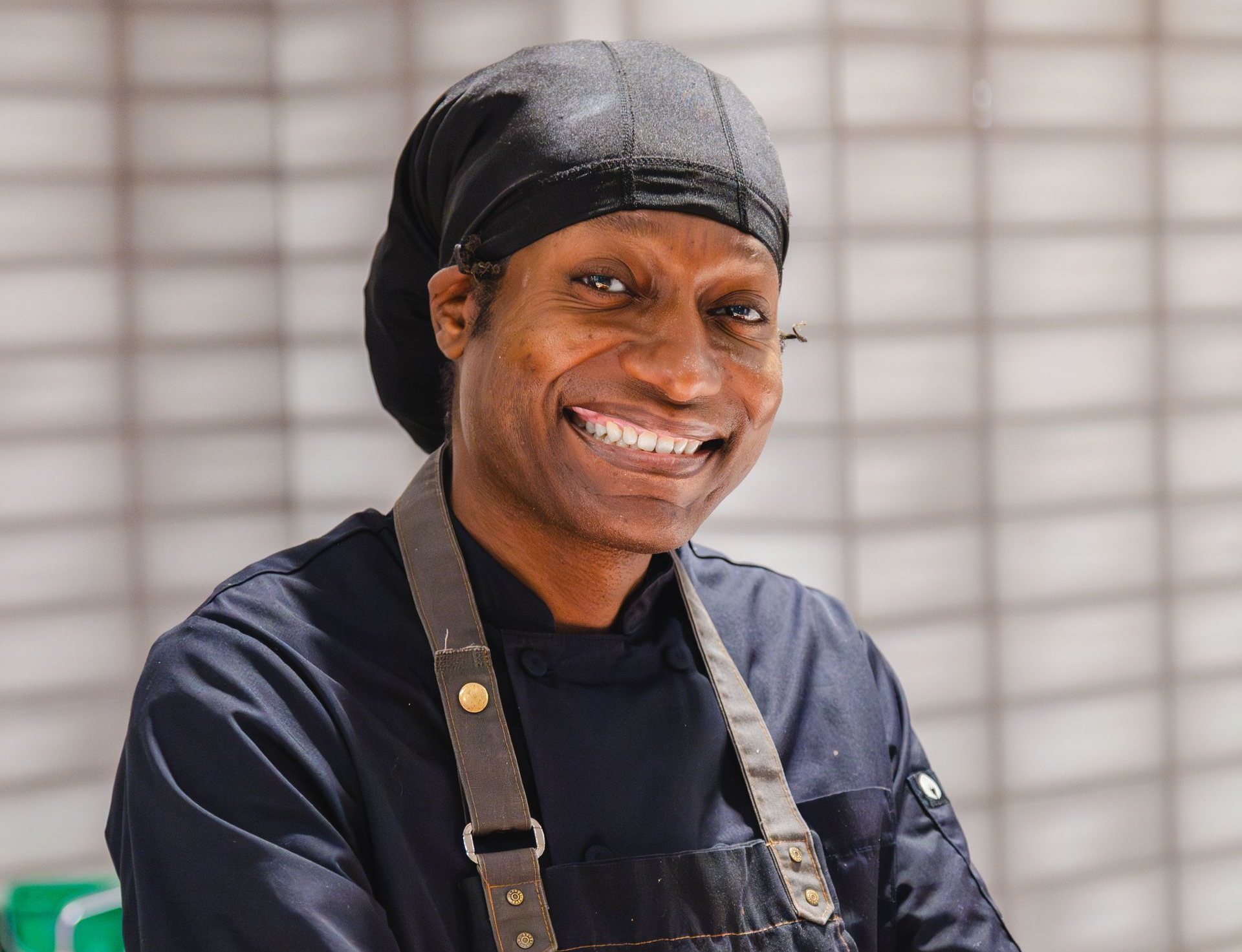 A group of chefs are posing for a picture in a kitchen.