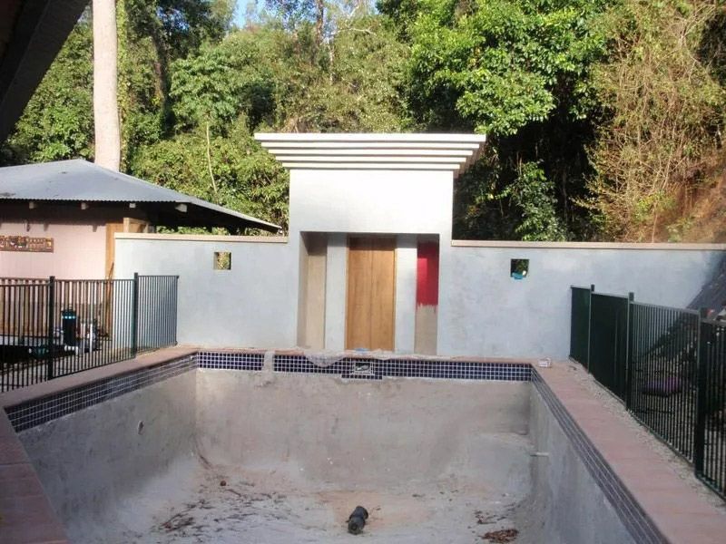 An Empty Swimming Pool With A Fence Around It — Justmill Carpentry & Building in Smithfield, QLD