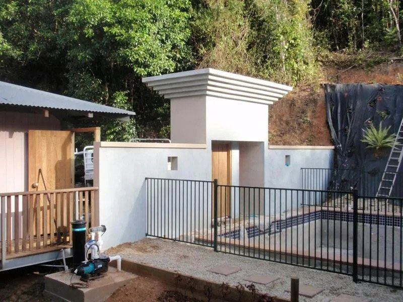 A Fence Surrounds A House And A Swimming Pool — Justmill Carpentry & Building in Smithfield, QLD