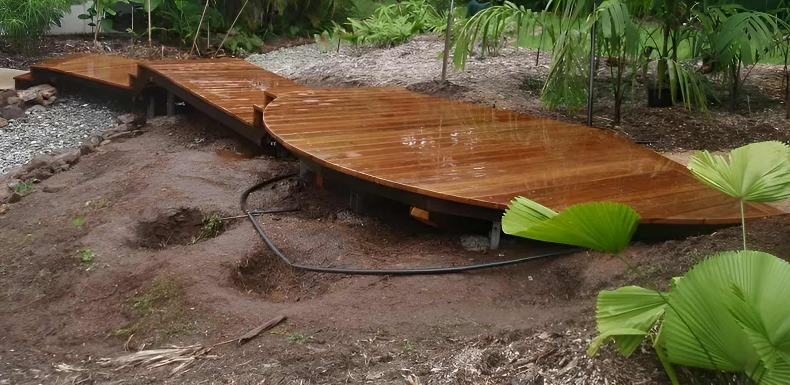 A Wooden Walkway Is Sitting In The Middle Of A Dirt Field — Justmill Carpentry & Building in Smithfield, QLD