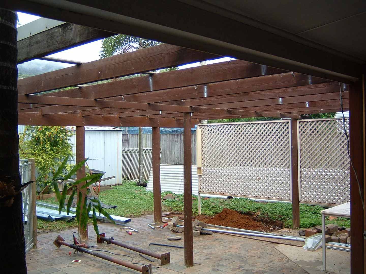 A Wooden Pergola Is Being Built In A Backyard — Justmill Carpentry & Building in Smithfield, QLD