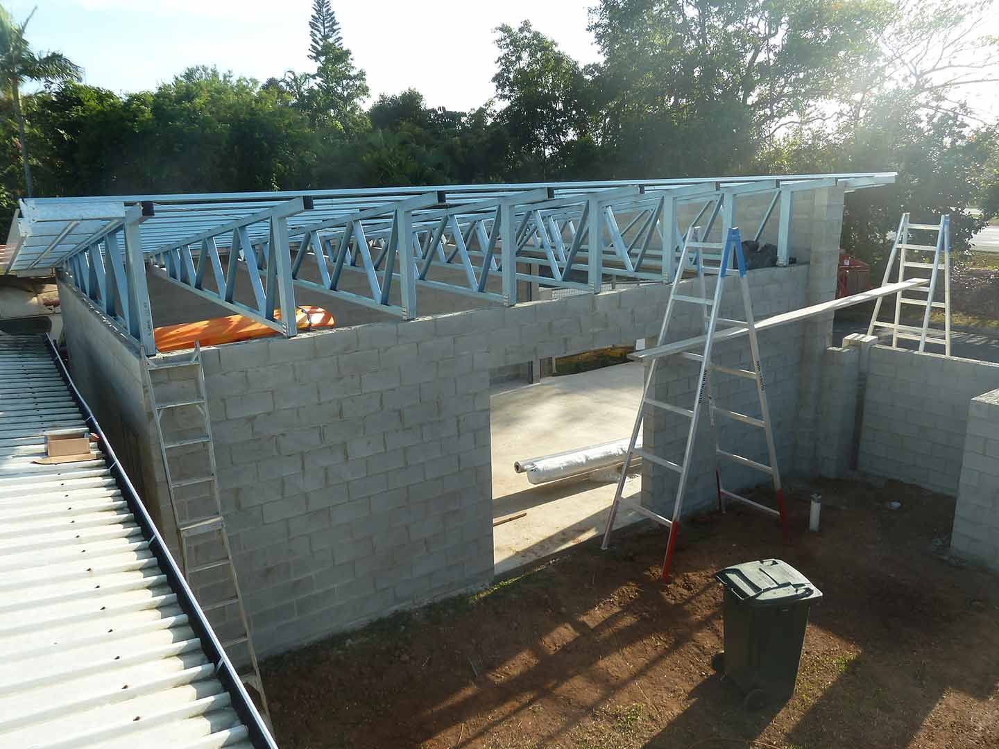 A Ladder Is Sitting In Front Of A Building Under Construction — Justmill Carpentry & Building in Smithfield, QLD