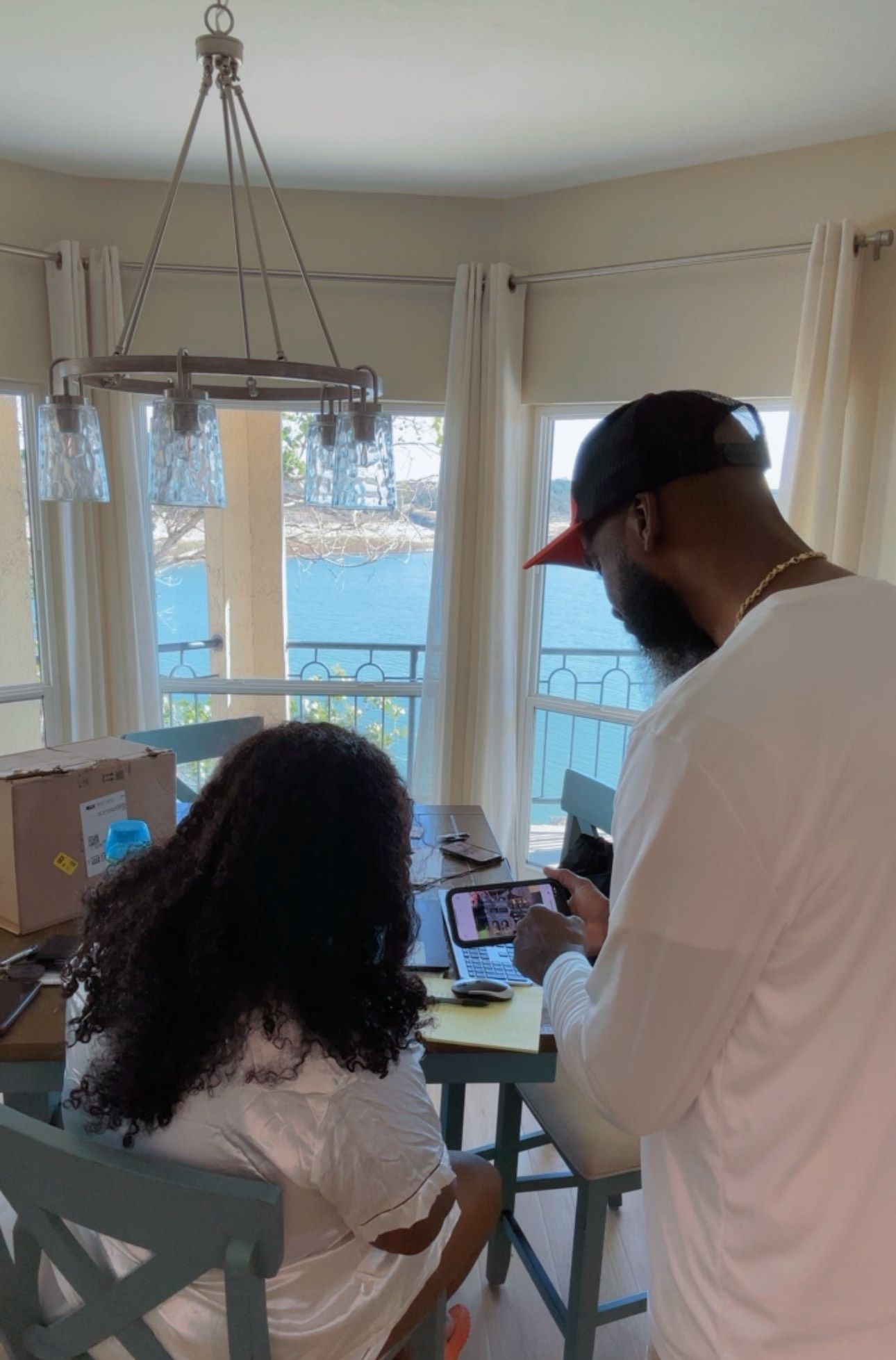 A man and a woman are sitting at a table looking at a tablet.