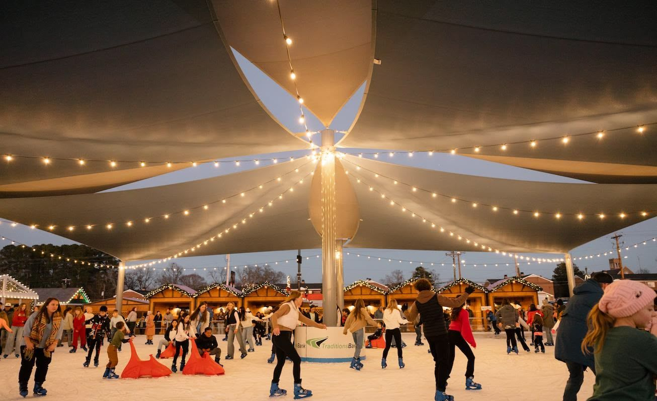 A little girl is ice skating on a rink.
