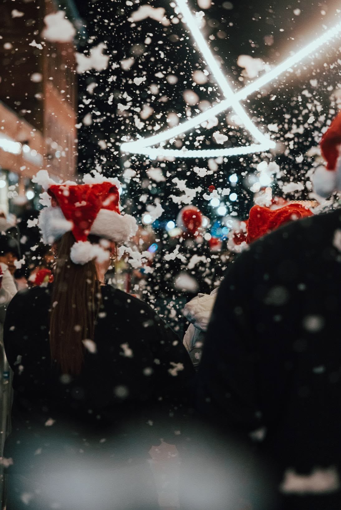 A group of people are standing in a line watching a parade.