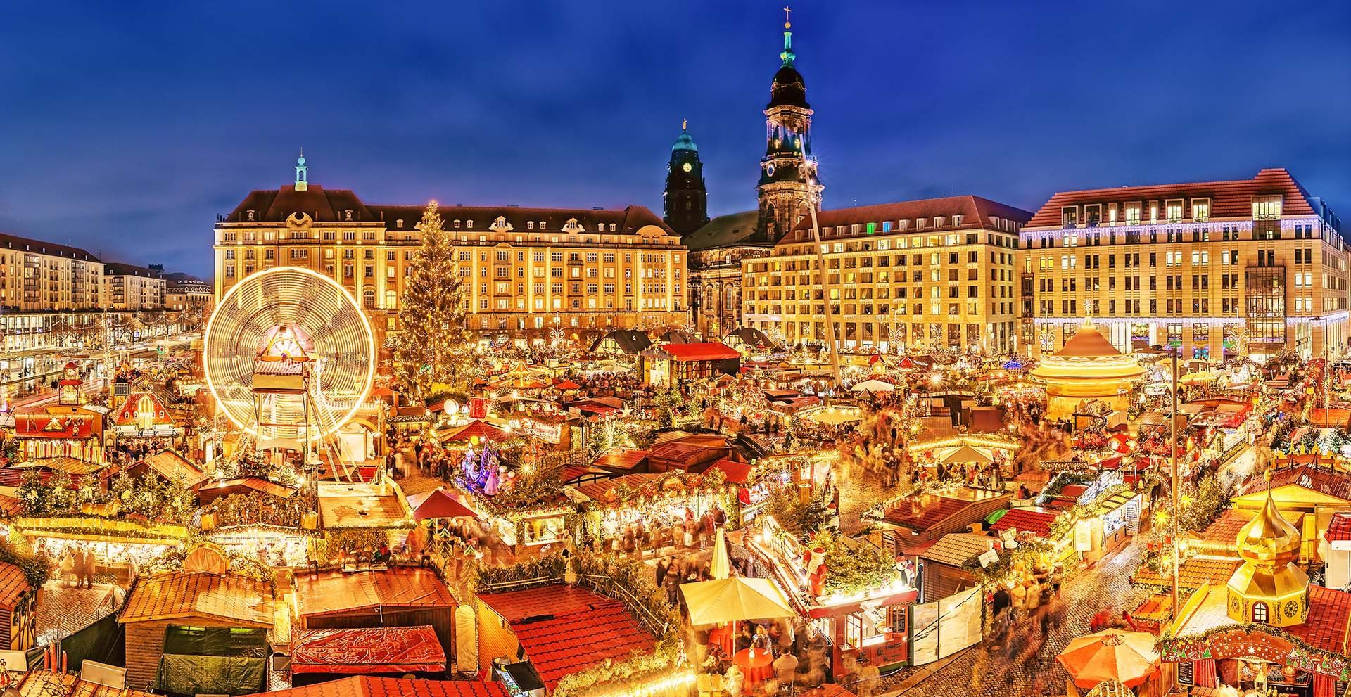 An aerial view of a christmas market in a city at night.