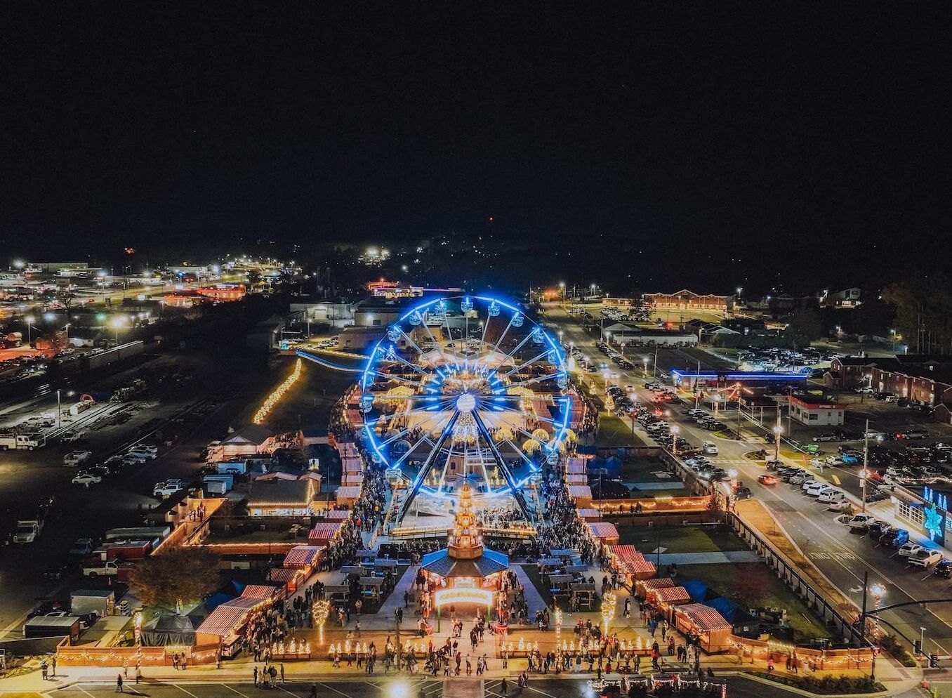 An aerial view of a christmas tree in front of an ice rink.