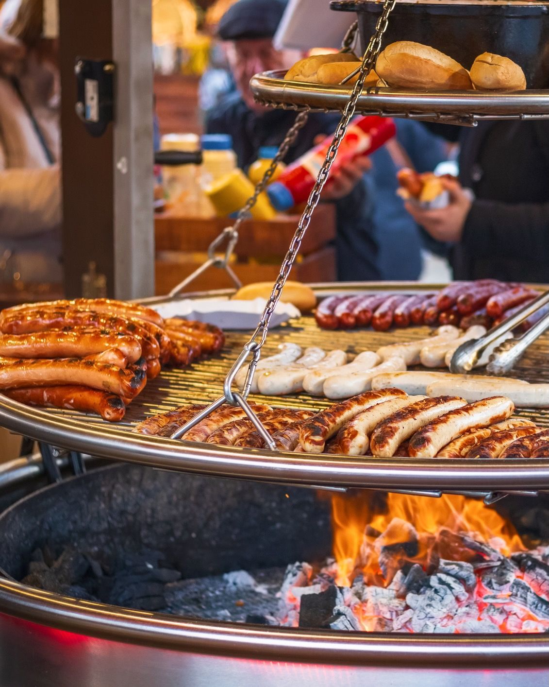 A bunch of sausages are cooking on a grill