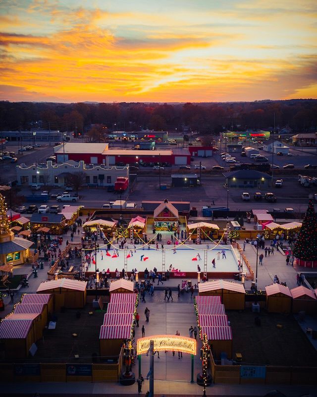 An aerial view of a christmas tree in front of an ice rink.