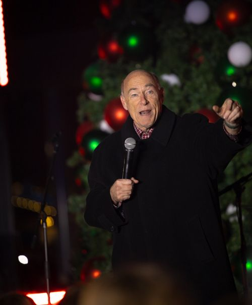 A sign that says cullman christkindlmarkt with fireworks behind it.