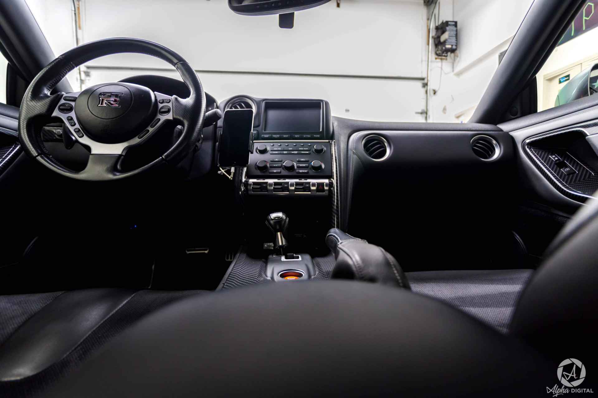 The inside of a car with a steering wheel and a radio.