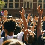A crowd of people with their hands in the air