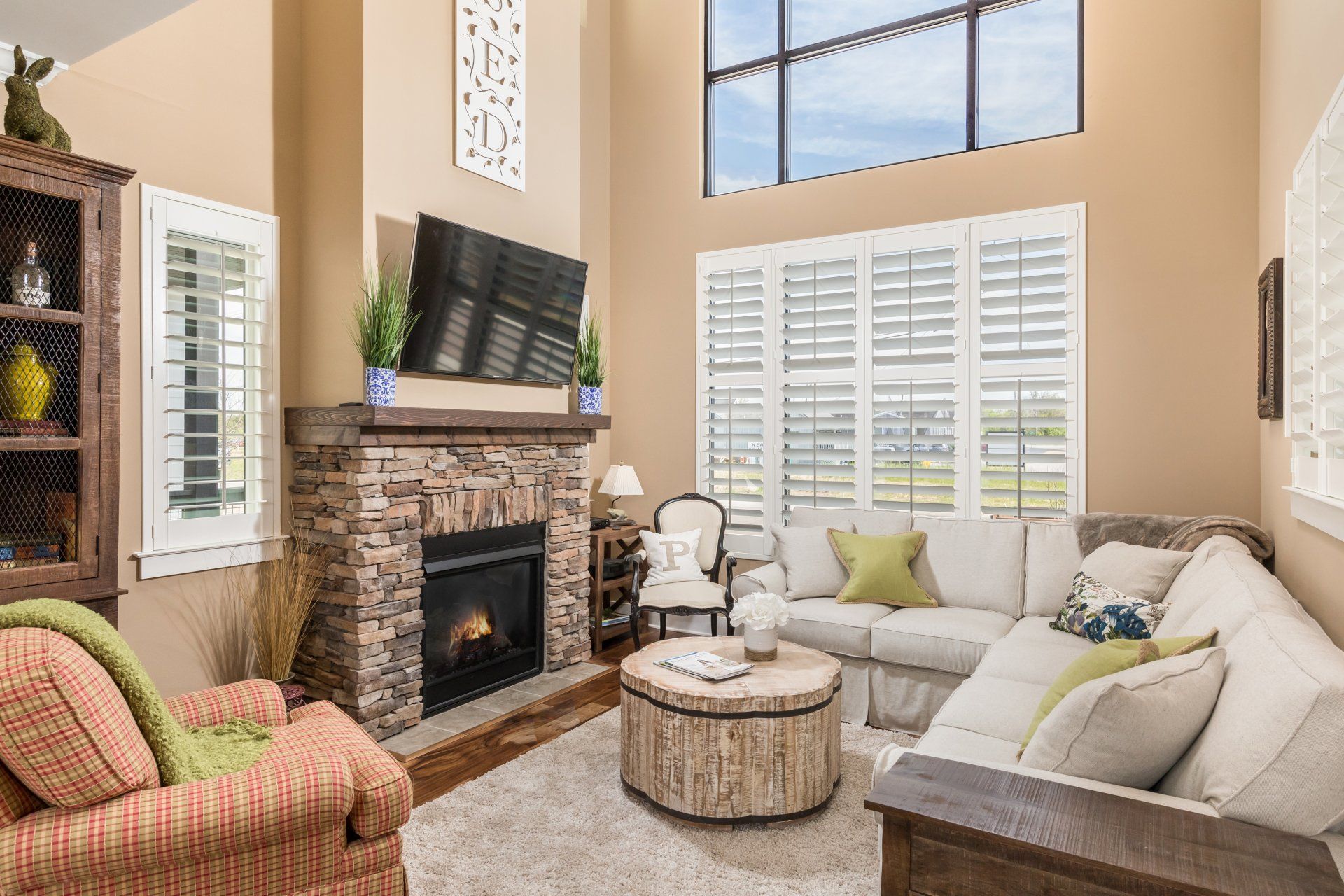 A living room with a fireplace , couch , chair and television.