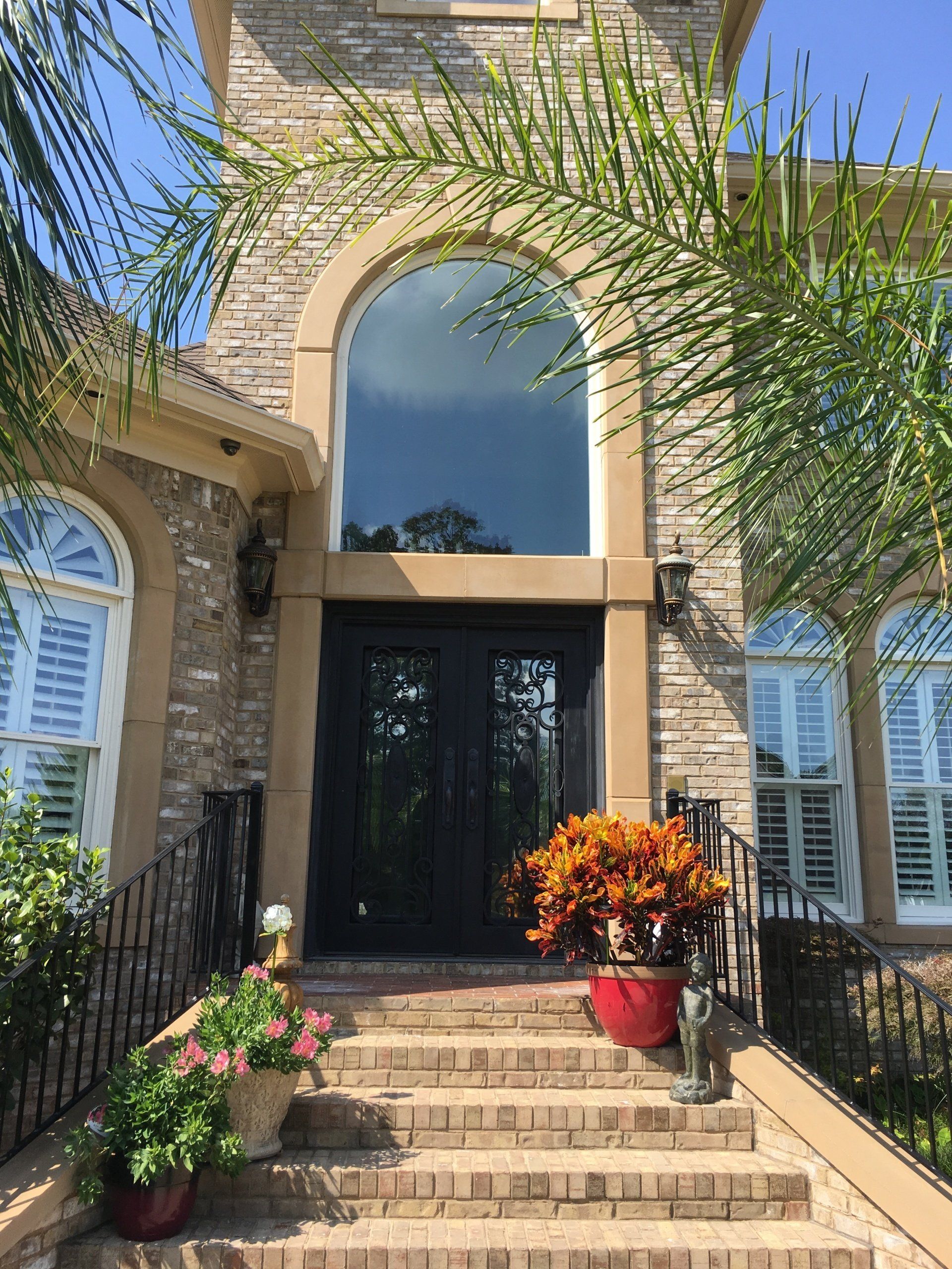 A large brick house with stairs leading up to the front door.