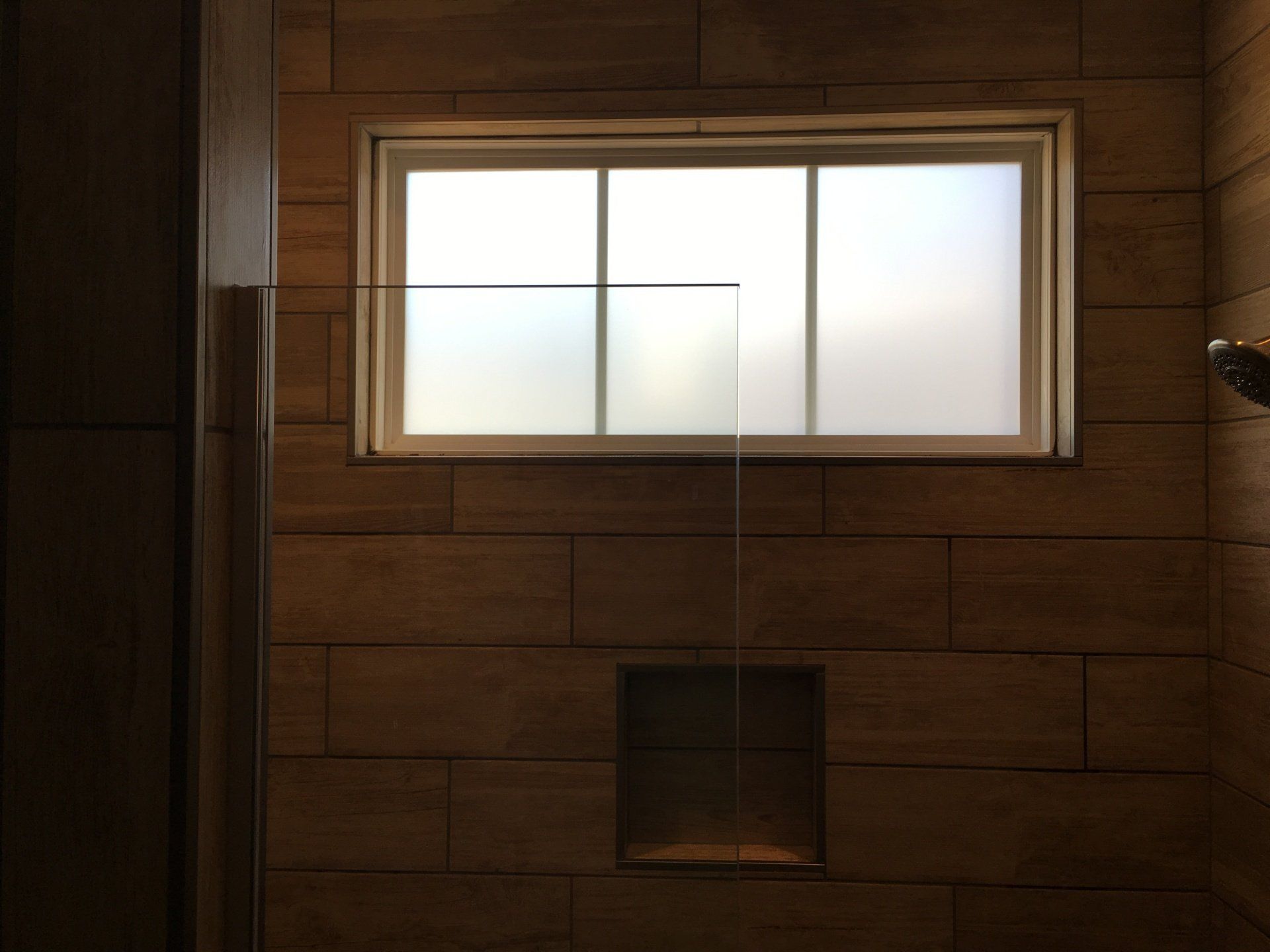 A bathroom with a window and a shower head