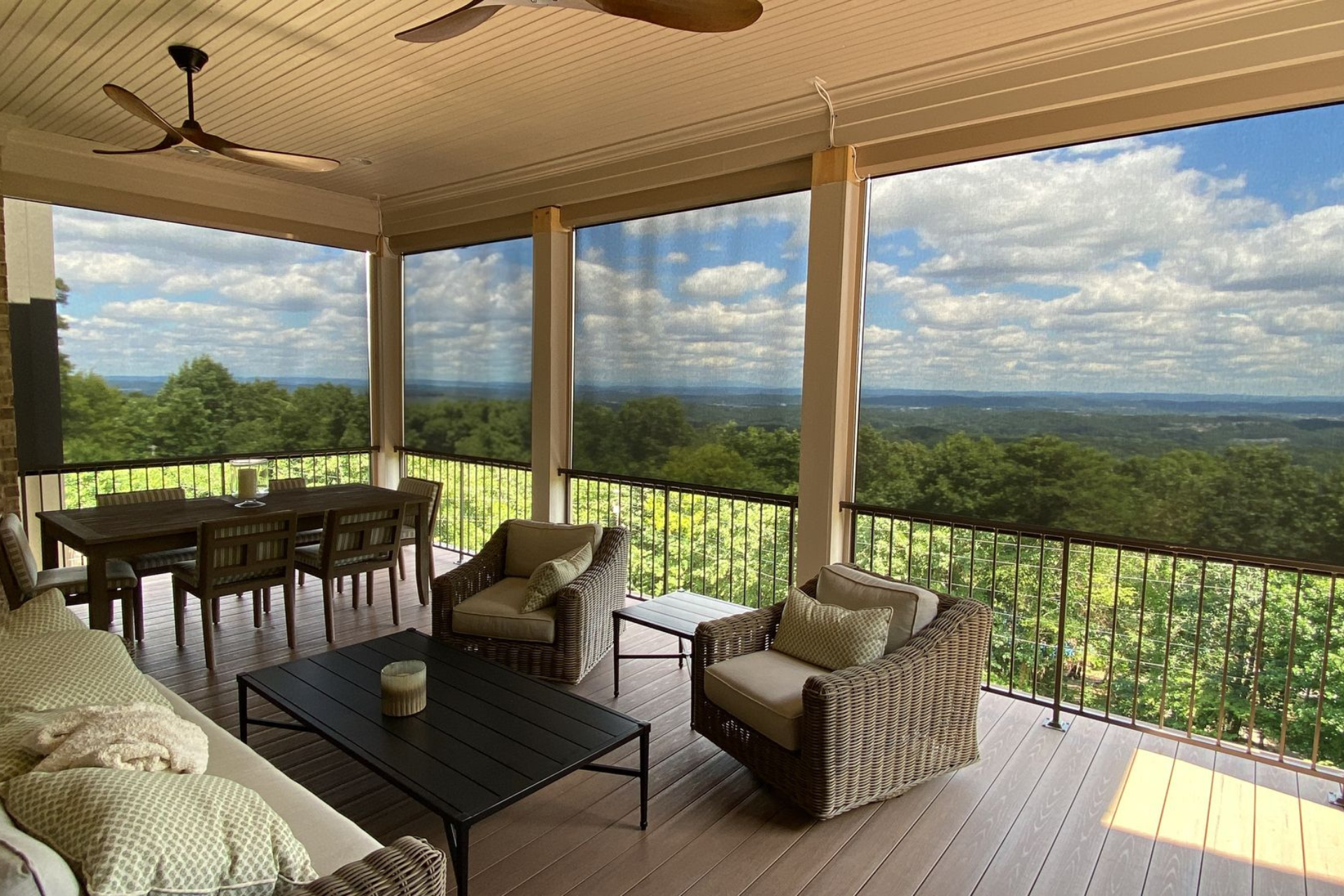 A screened in porch with a view of a forest.