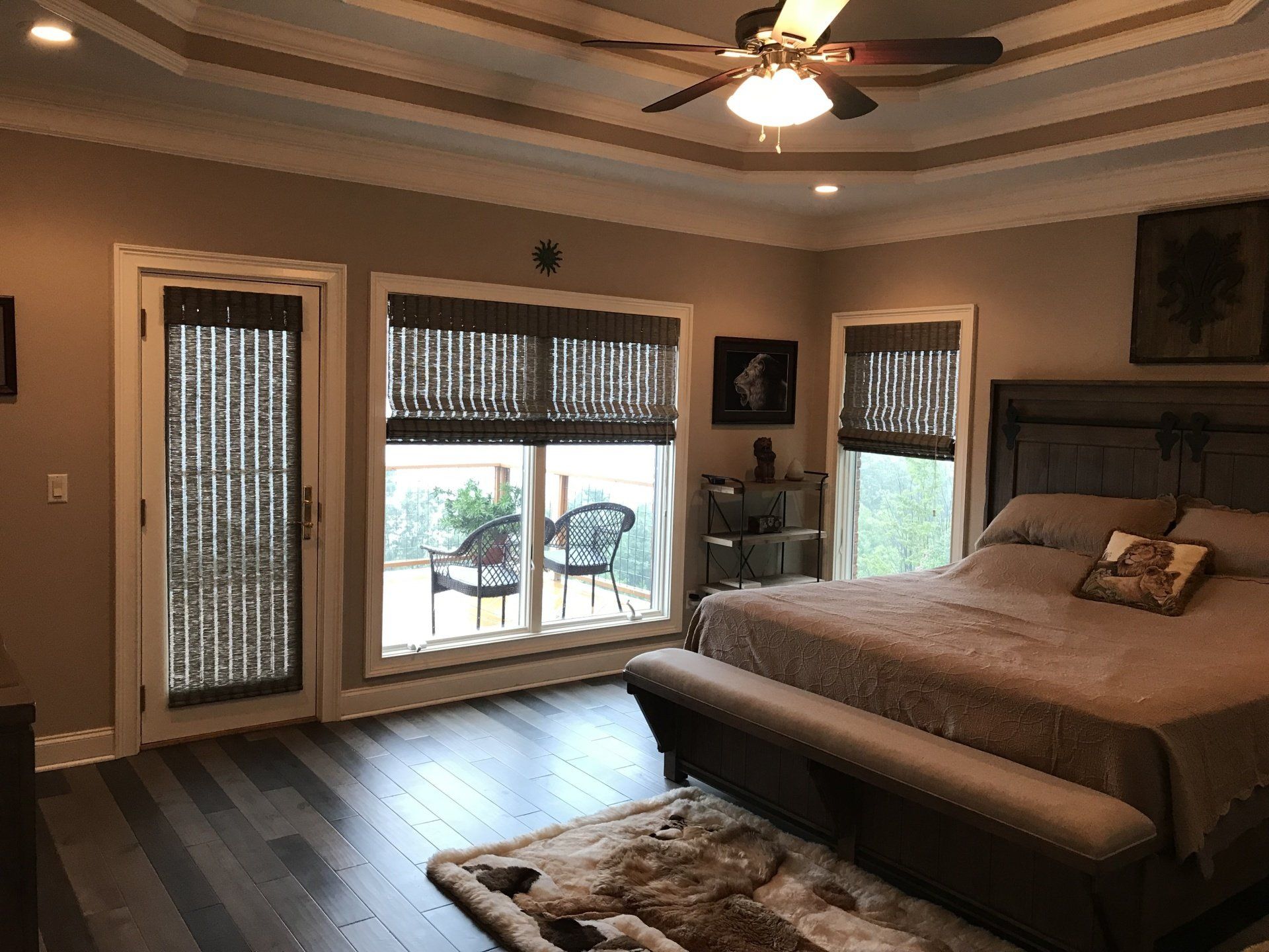 A bedroom with a large bed and a ceiling fan.