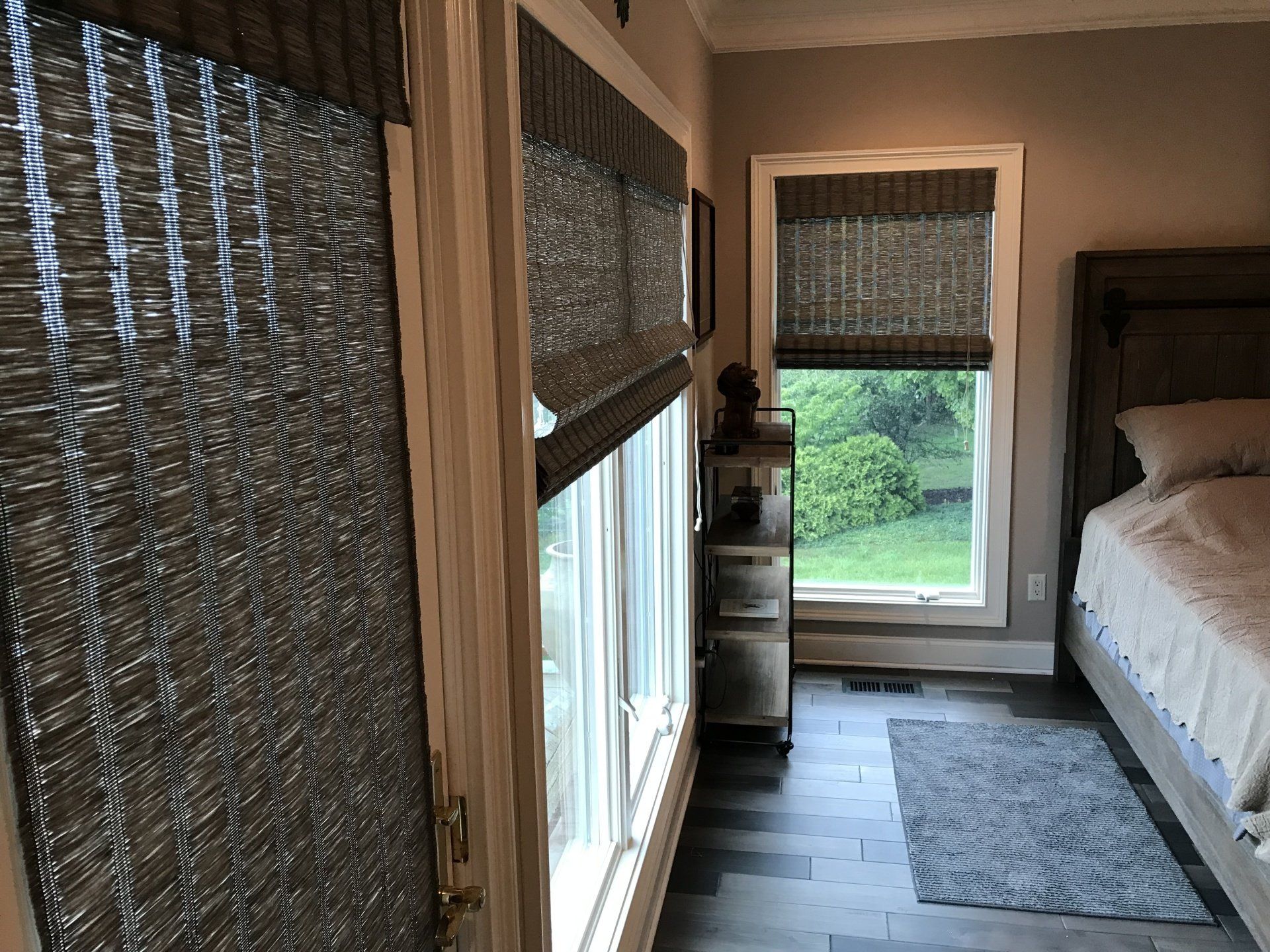 A bedroom with a bed , a desk , and a large window.