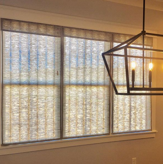 A dining room with a large window and a lantern hanging from the ceiling.