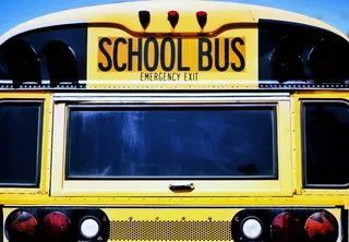 A yellow school bus with the word school bus on the top