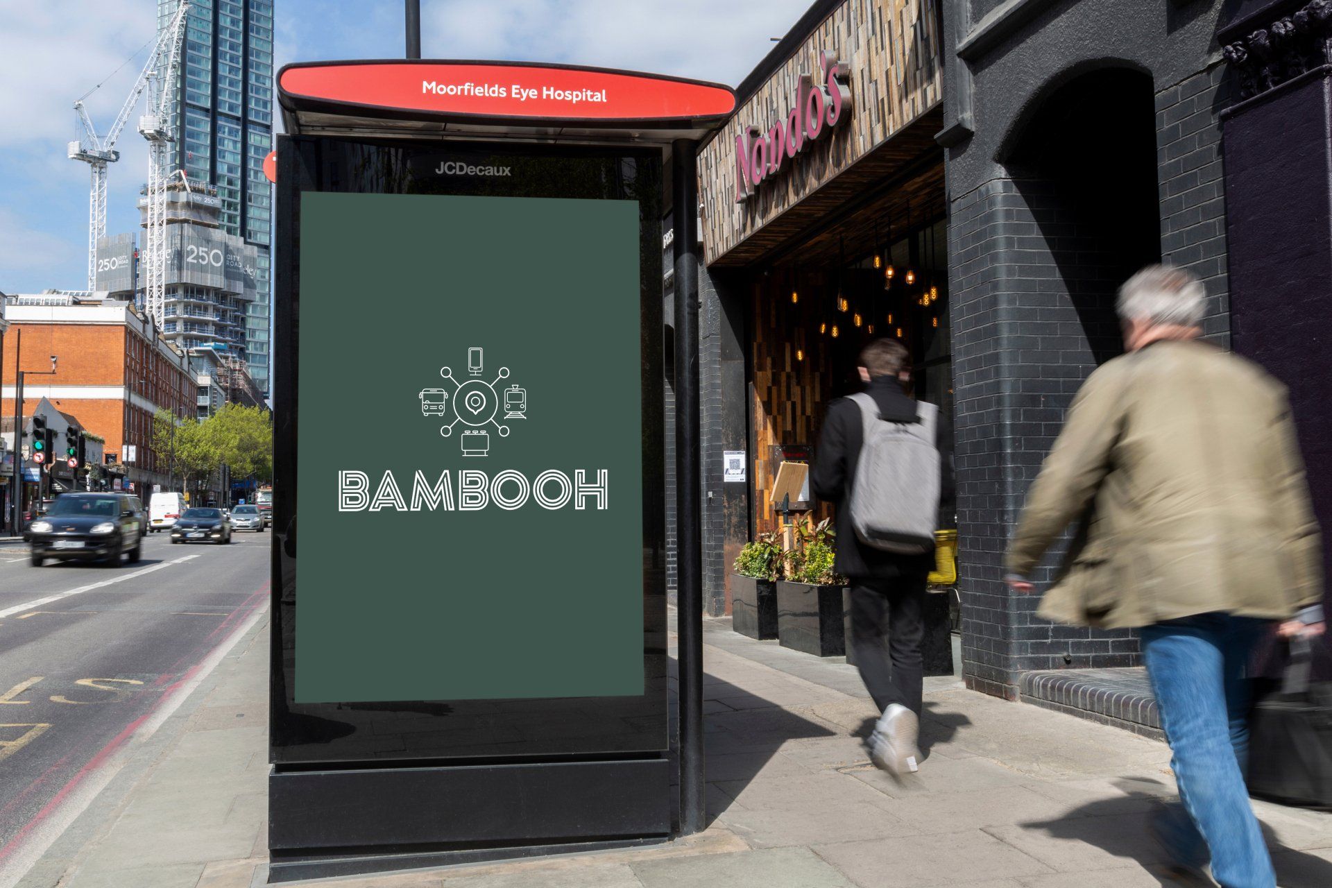 A man is walking past a bus stop with a bambooh sign on it.