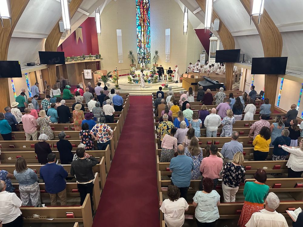 Congregation in a church sanctuary during a service, facing the altar and stained-glass window. Congregation in a church sanctuary during a service, facing the altar and stained-glass window.