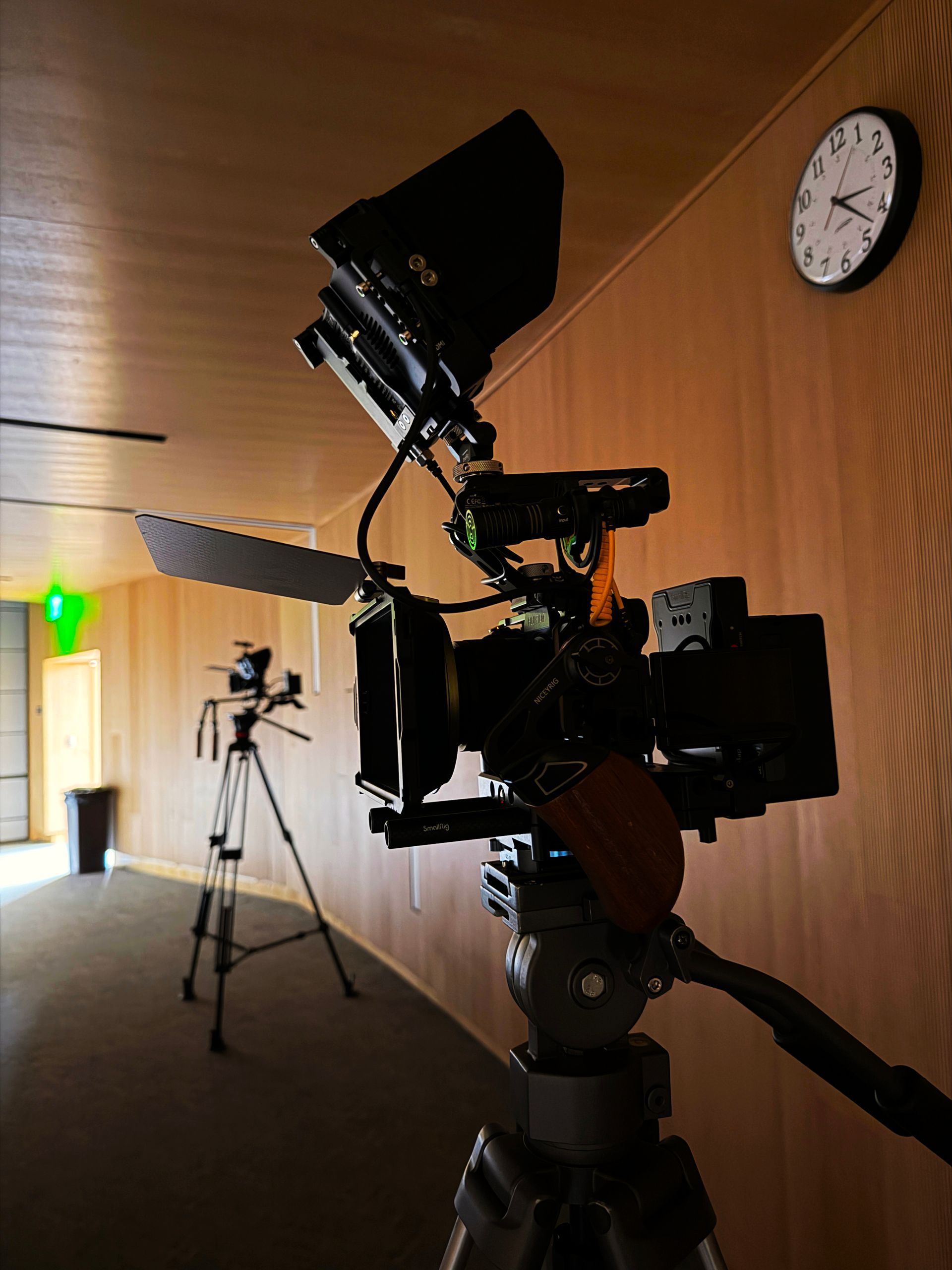 Video camera filming a banquet hall with tables set for an event.