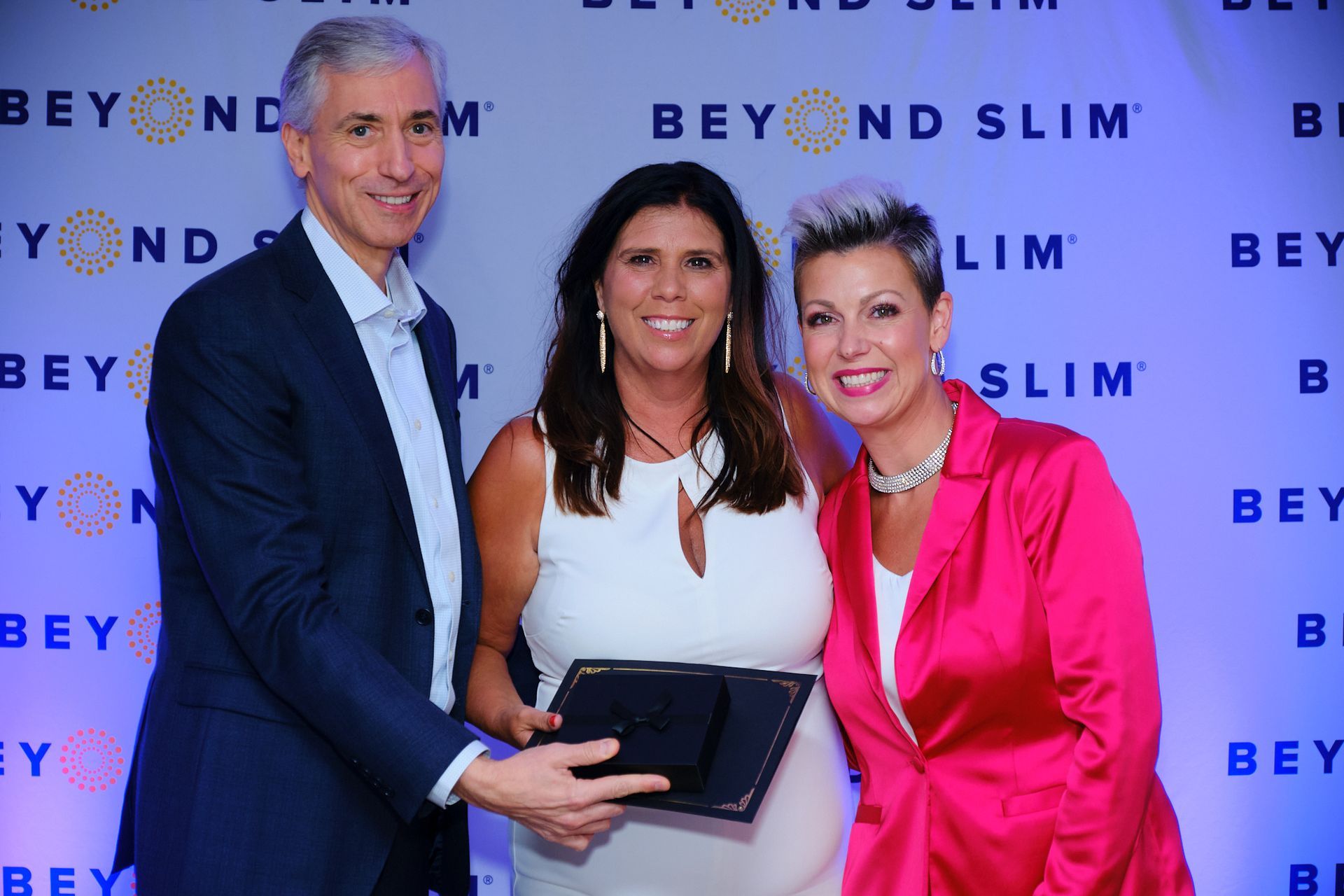 Three people stand before a 