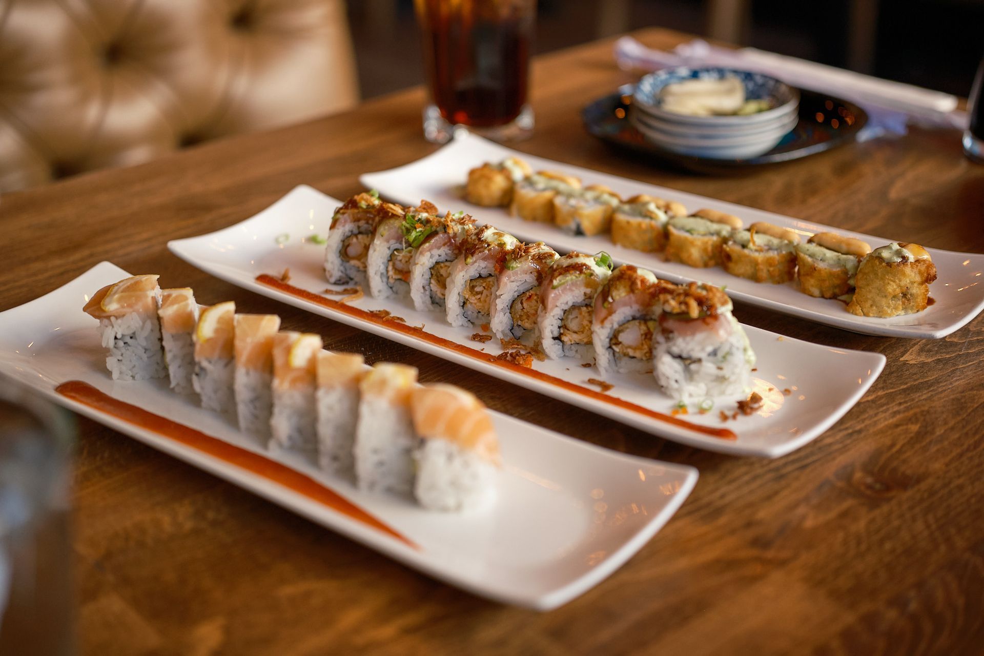 A person with a beard, wearing a black cap, dark jacket, and patterned shirt.