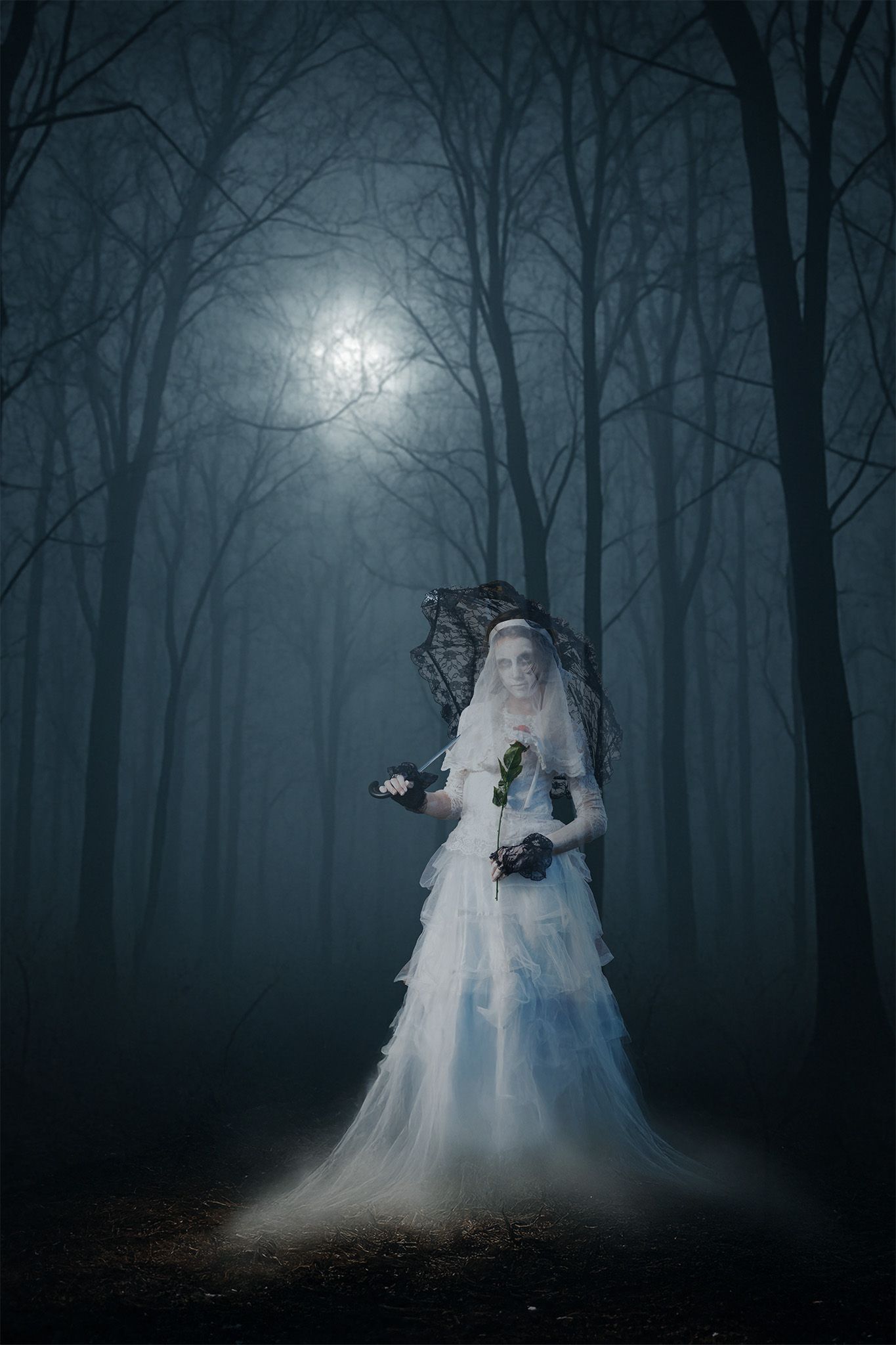 A person in a voluminous white gown and lacy headpiece stands in a dark, foggy forest under a glowing full moon.