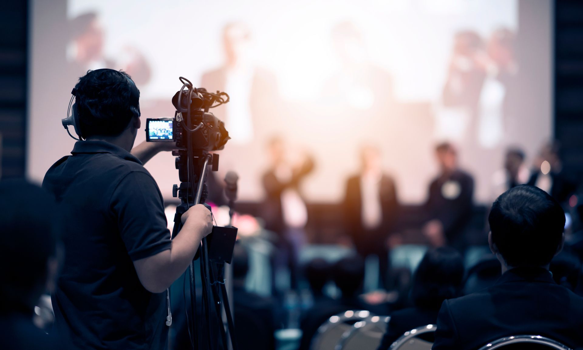 Videographer films a presentation at an event.