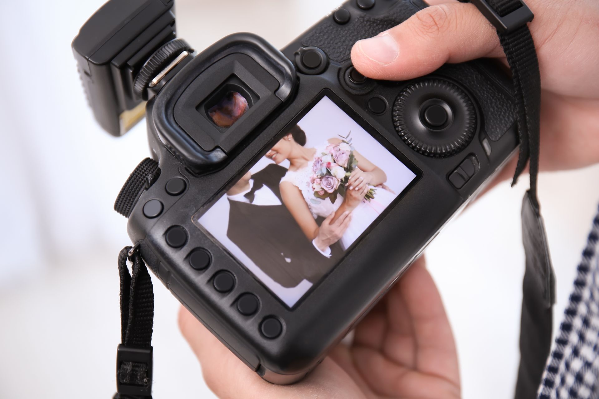 Close-up of a person holding a digital camera.