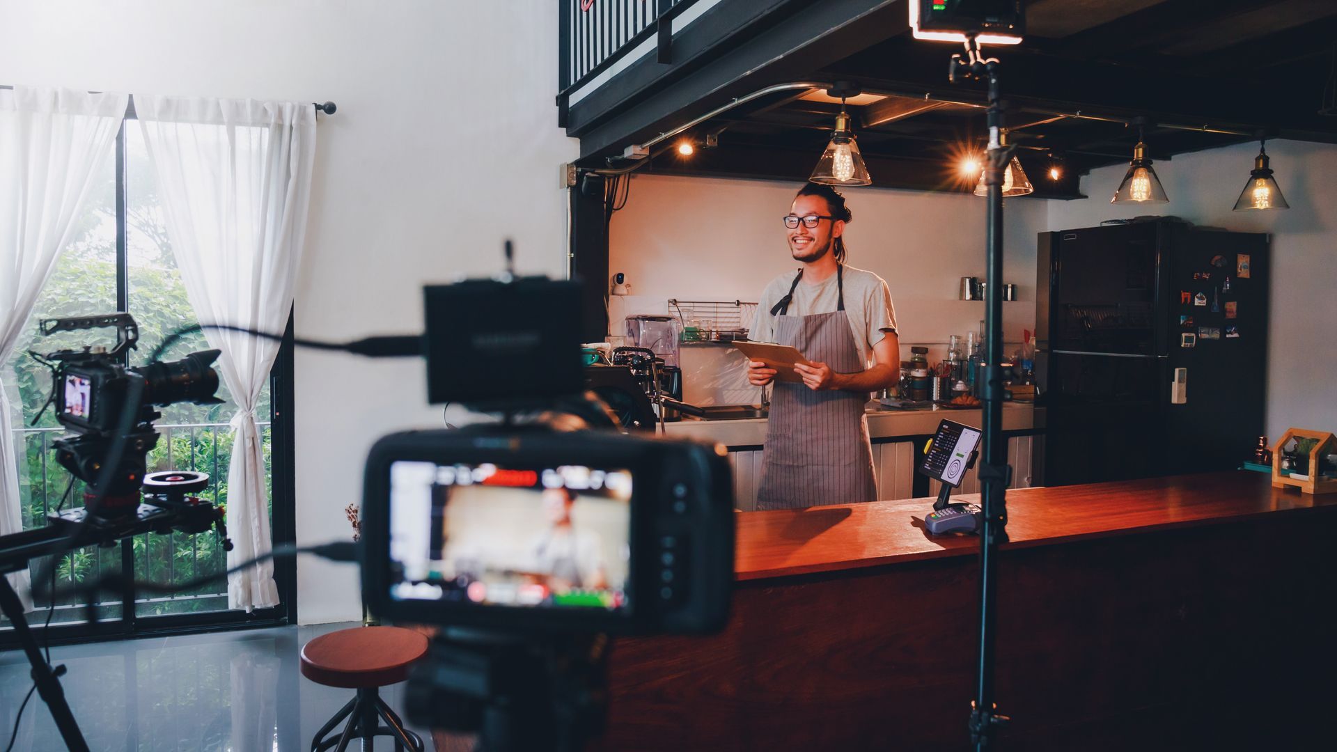 Person filming a video in a kitchen.