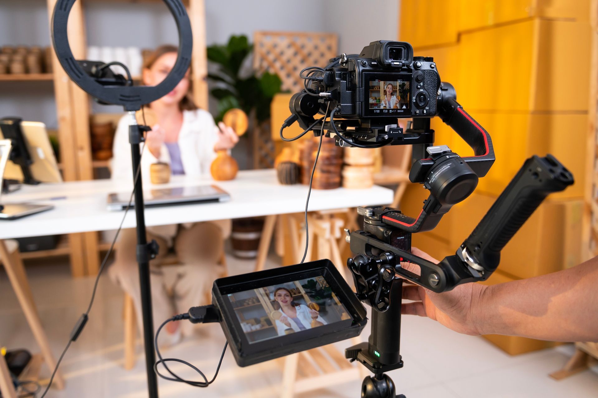 A person filming a video with a camera on a gimbal and monitor.