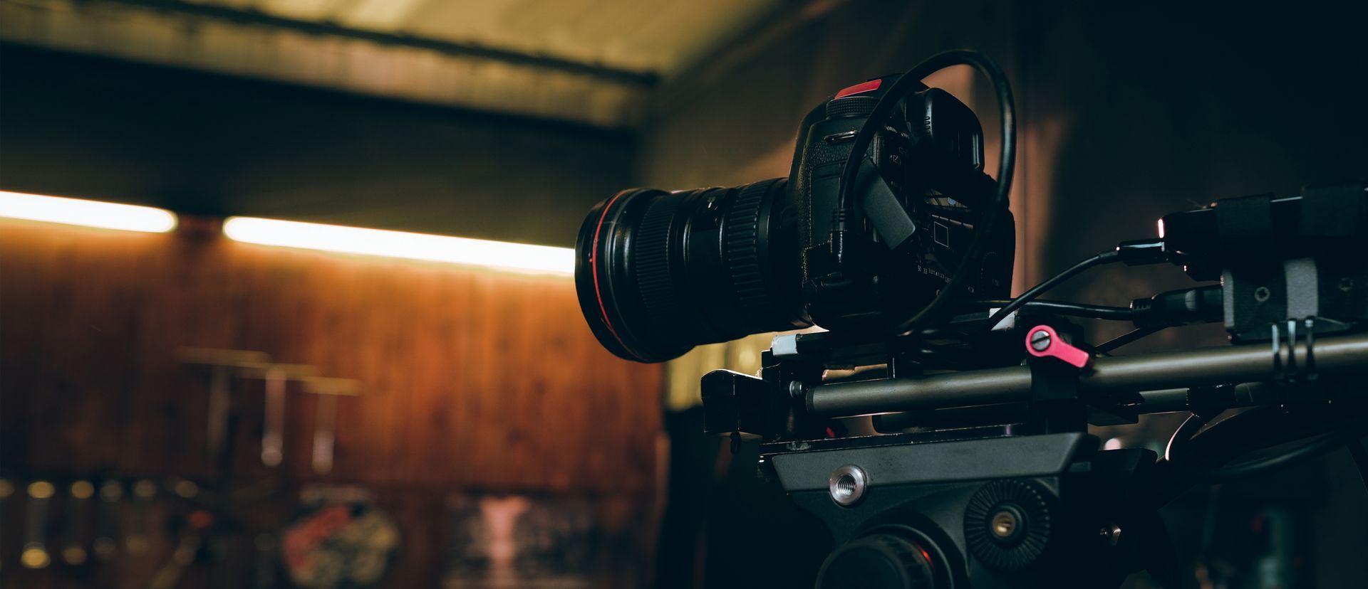 A black camera with a large lens is mounted on a tripod.