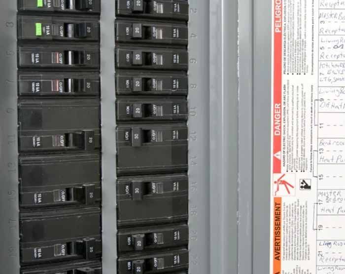Electrical circuit breaker panel with several switches in the on position and one in the off position.