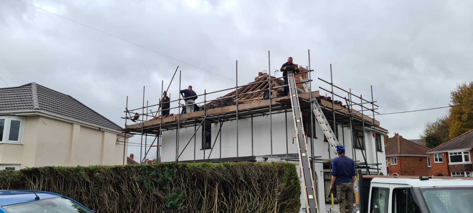 various traders working on a house roof