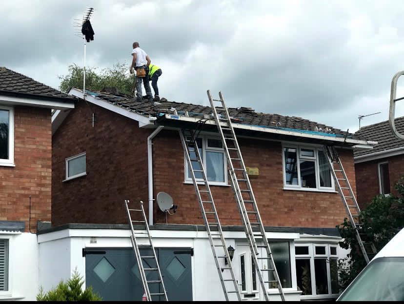 two workers working on a roof