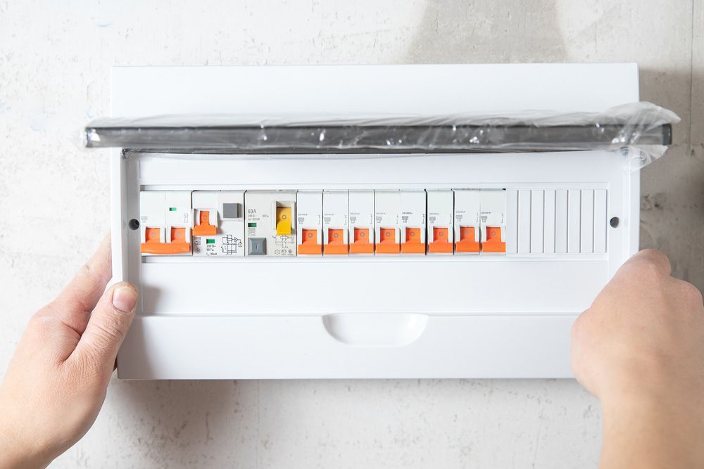 A Person Is Holding A Electrical Box With A Bunch Of Switches In It — All Star Electrical Services in Figtree, NSW