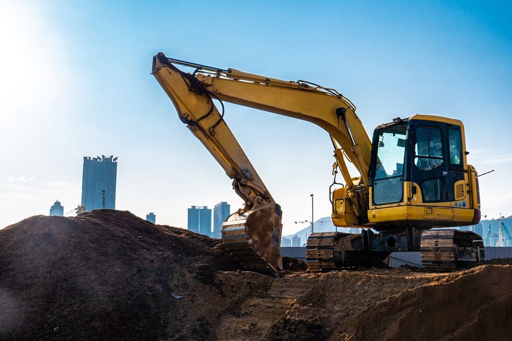 A Yellow Excavator is Digging a Hole at a Construction Site — Queanbeyan East, NSW — Traditional Stone Structures