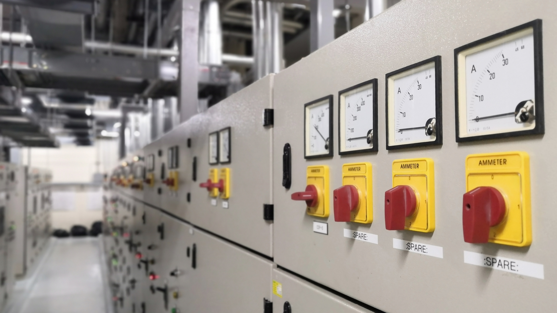 A row of electrical switches and gauges on a wall.